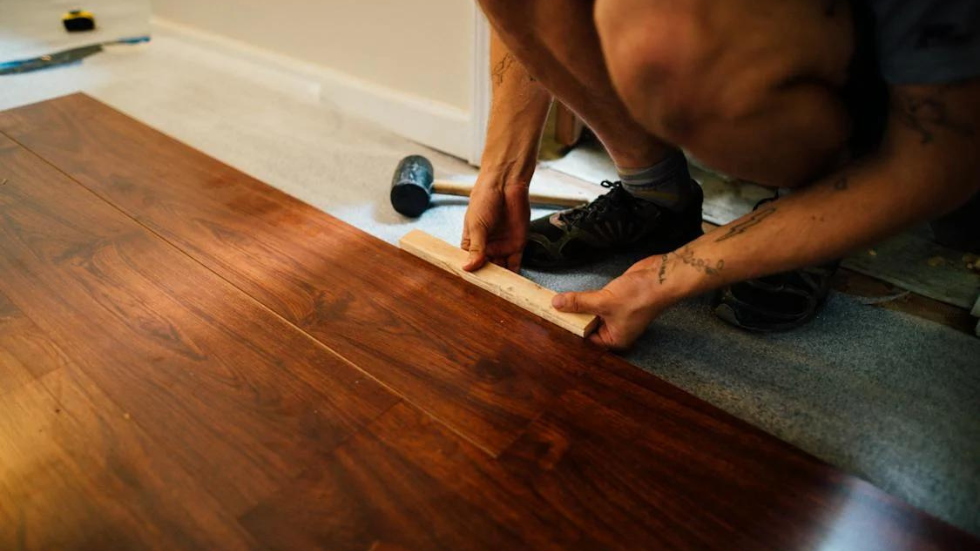 man measuring wood floor