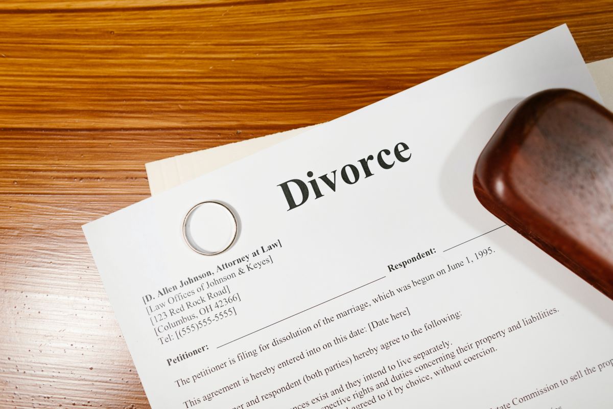 Papéis relativos a divórcio, com aliança, numa superfície.